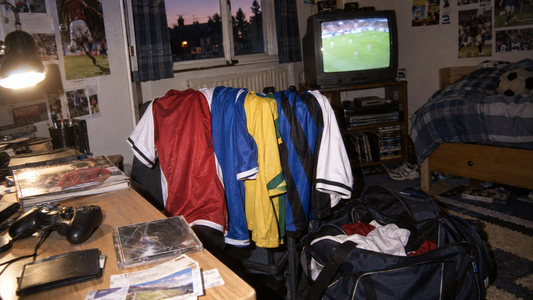 Maillots de football colorés dans une chambre de supporter du début des années 2000 avec télévision cathodique