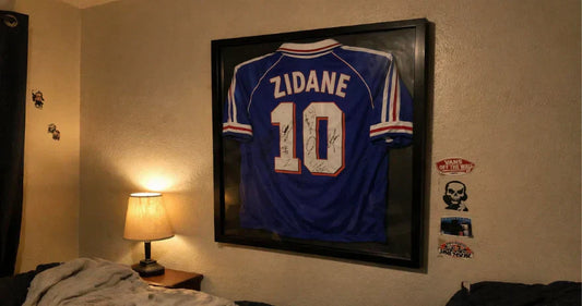 Maillot Zidane numéro 10 France 1998 encadré accroché au mur d’une chambre éclairée par une lampe de chevet