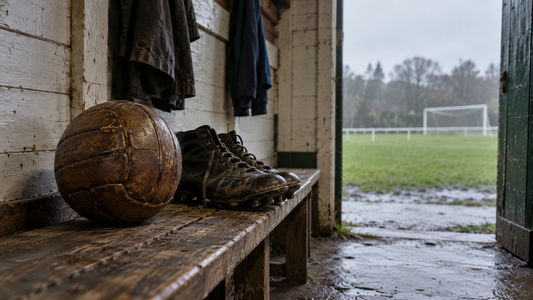 Ballon de football en cuir et anciennes chaussures à crampons dans un club-house